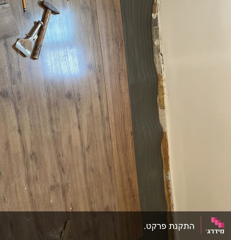 התקנת פרקט עץ עם כלים על הרצפה